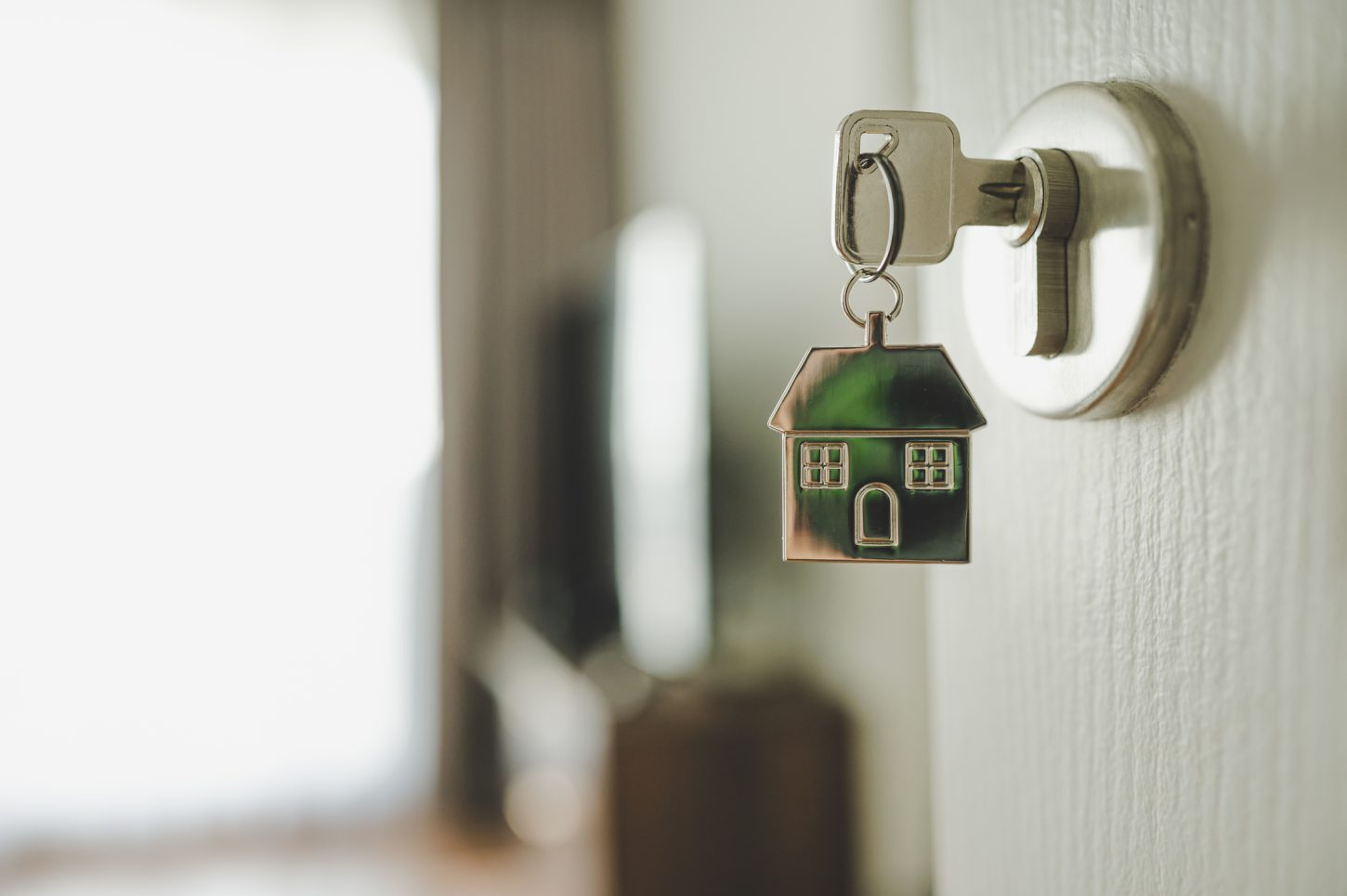 keys in a door with a home keychain